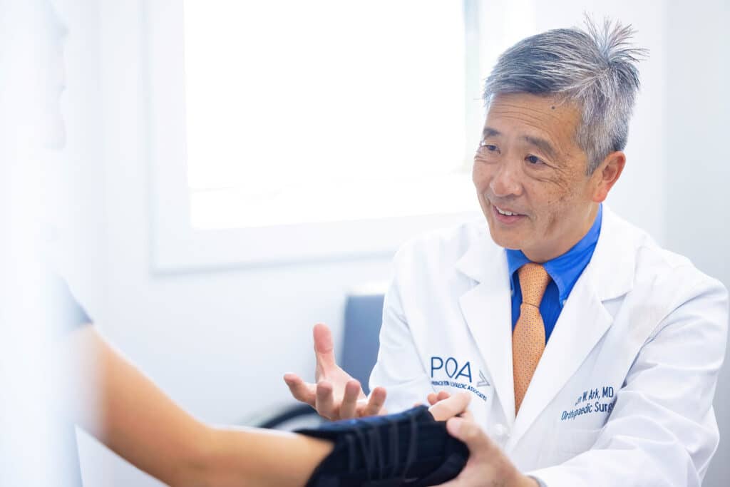 Dr. Ark helps a patient put on a removable splint for ganglion cyst treatment - Princeton Orthopaedic Associates