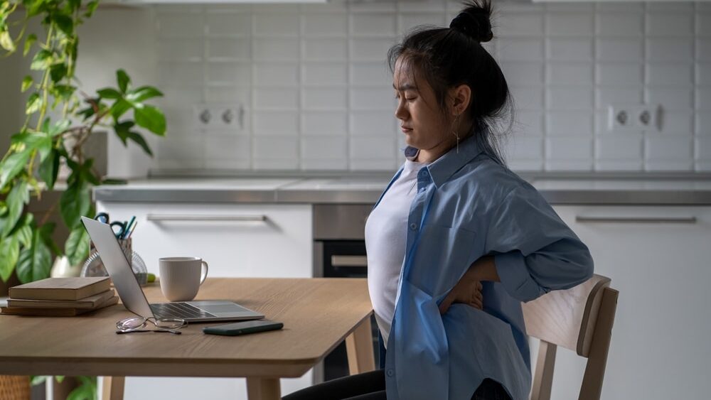 unhealthy,suffering,from,backache,while,sits,with,laptop, bad posture