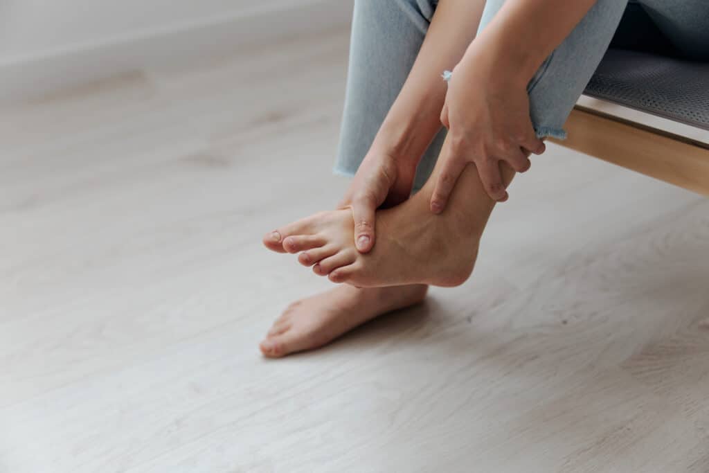 Closeup shot of pain leg foot suffering tanned beautiful young Asian woman touch ankle at home interior living room Injuries Poor health Illness concept Cool offer Banner - Princeton Orthopaedic Associates