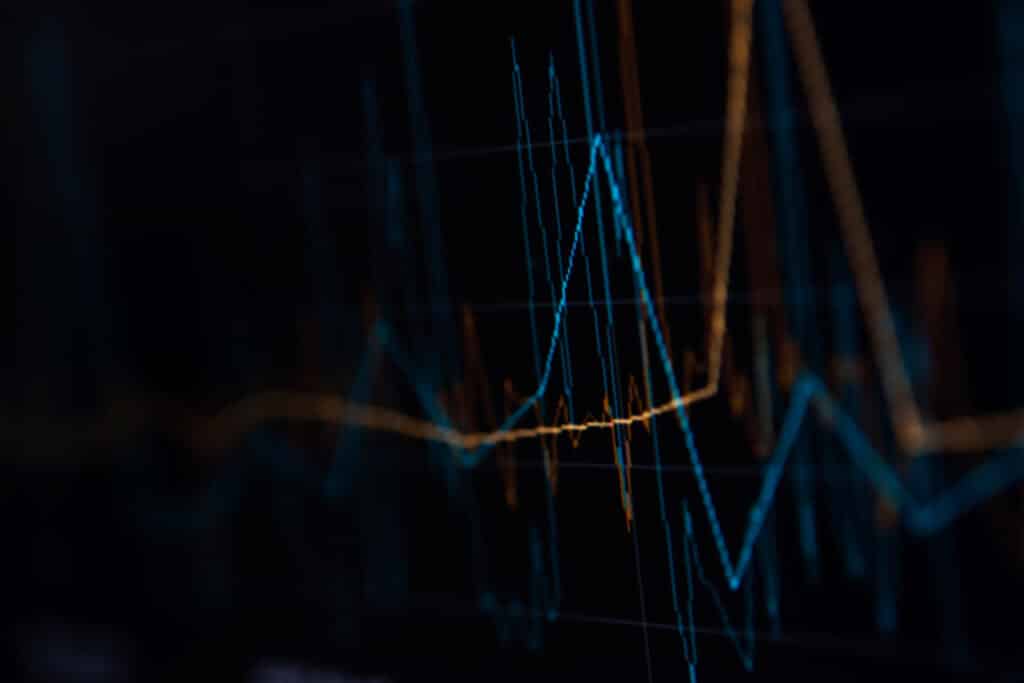 Abstract data visualization with neon blue and orange line graphs on a dark background