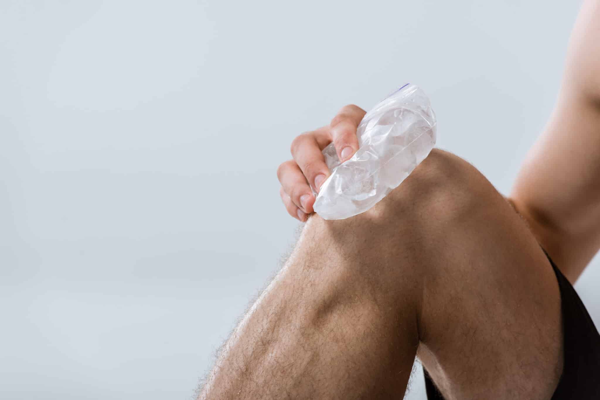 Person applying a crushed ice pack to their shoulder for cold therapy.