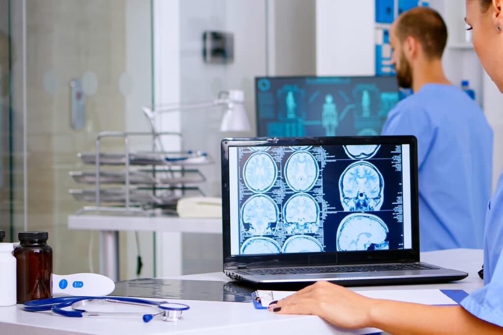 Shoulder MRI images displayed on a monitor for review alongside exam findings